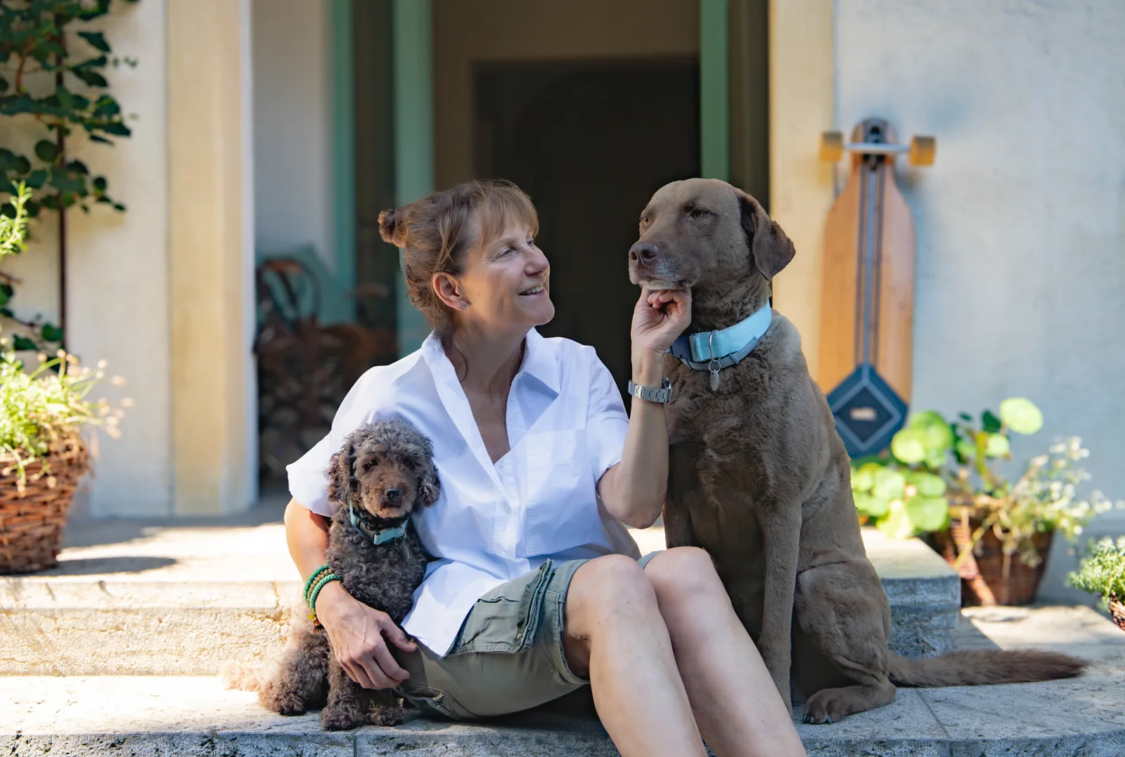 Petra Dürr mit ihren beiden Hunden vor einer Hauswand